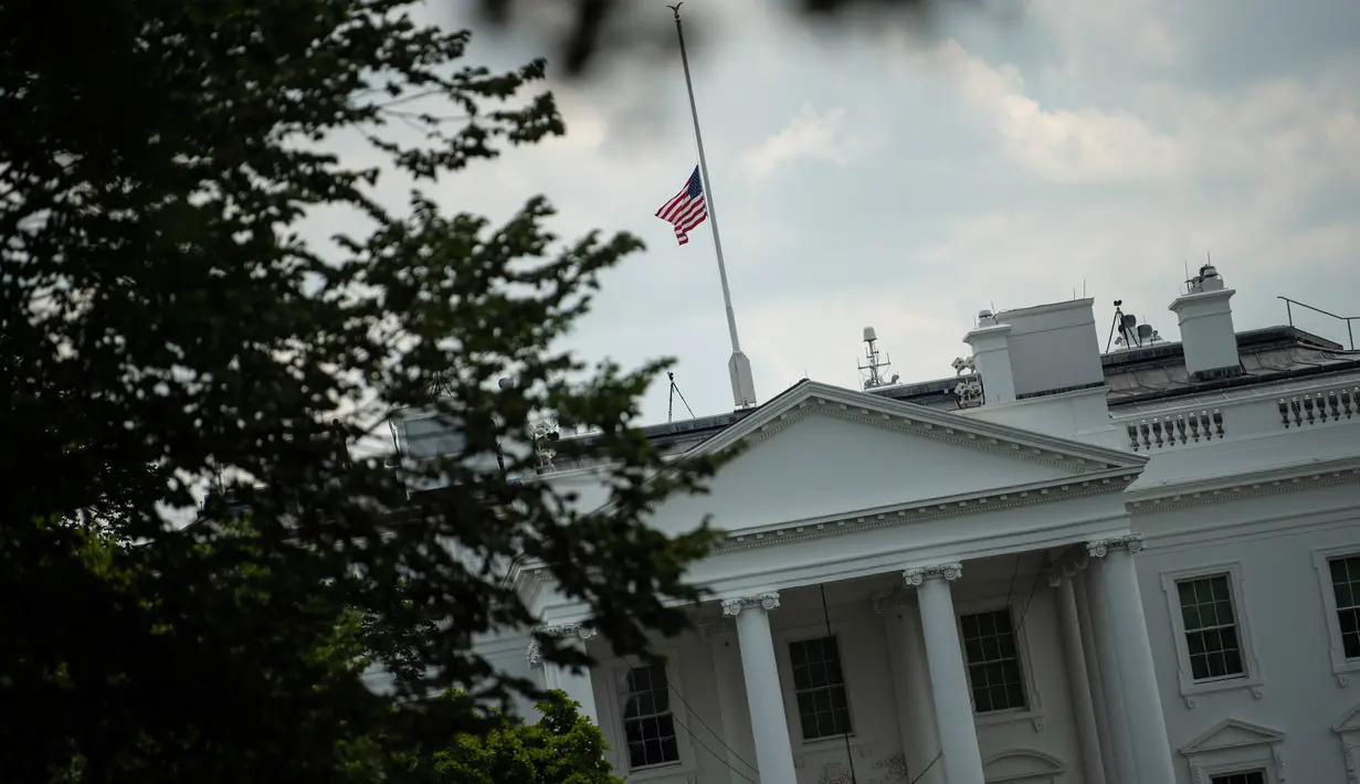 Pemandangan bendera nasional AS yang berkibar setengah tiang di Gedung Putih, Washington DC, Minggu (4/8/2019). Presiden Donald Trump memerintahkan bendera dikibarkan setengah tiang selama lima hari sebagai simbol dukacita atas dua penembakan massal di El Paso, Texas, dan Ohio. (Eric BARADAT/AFP)