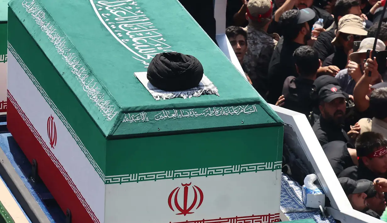 Para pelayat berkumpul di sekitar peti mati pemimpin tertinggi Iran yang terbunuh, Ali Khamenei, dan anggota keluarganya saat prosesi pemakaman menuju Lapangan Azadi di Teheran, Senin, 6 Juli 2026. (AFP/ Atta Kenare)