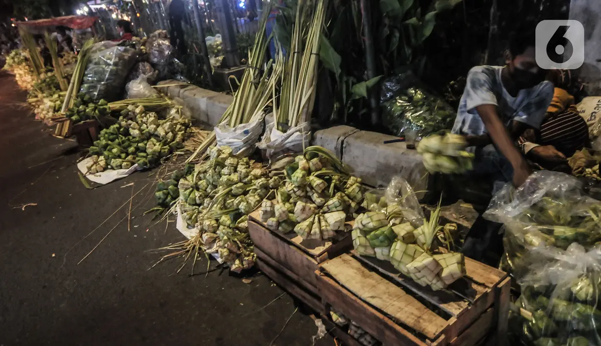 Aktivitas pedagang saat membuat bungkus atau tali ketupat di Pasar Klender, Jakarta Timur, Selasa (11/5/2021) malam. Menjelang Hari Raya Idul Fitri, Pasar Klender merupakan salah satu lokasi yang ramai dikunjungi warga untuk berburu ketupat, terutama saat malam hari. (merdeka.com/Iqbal S Nugroho)