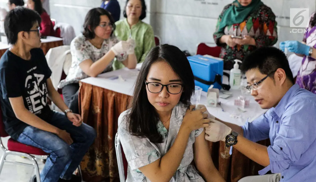 Mahasiswi saat disuntik vaksin difteri di Universitas Tarumanegara, Jakarta, Kamis (14/5). Ratusan mahasiswa/wi yang berusia di bawah 19 tahun mendapatkan imunisasi (Td) sebagai antisipasi mewabahnya penyakit difteri. (Liputan6.com/Faizal Fanani)