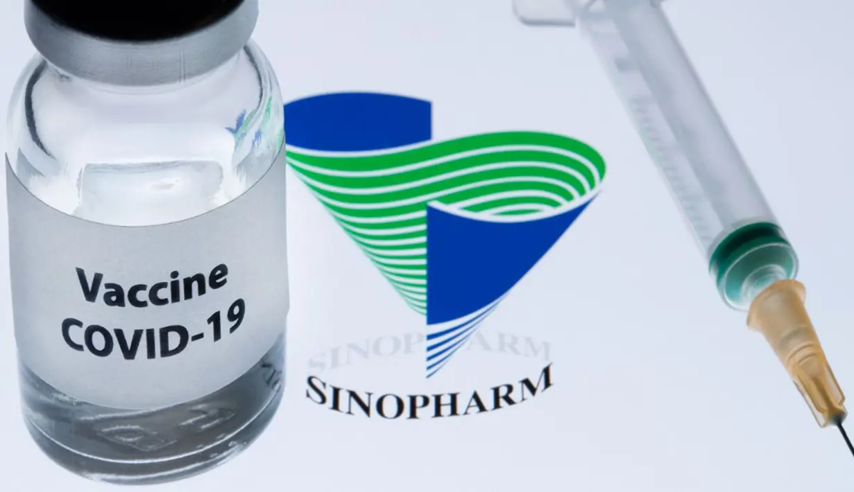 Botol bertuliskan "Vaksin COVID-19" terlihat di sebelah logo Sinopharm, 23 November 2020. Pemerintah Uni Emirat Arab (UEA) telah menjamin vaksin COVID-19 buatan Sinopharm halal. (JOEL SAGET/AFP)