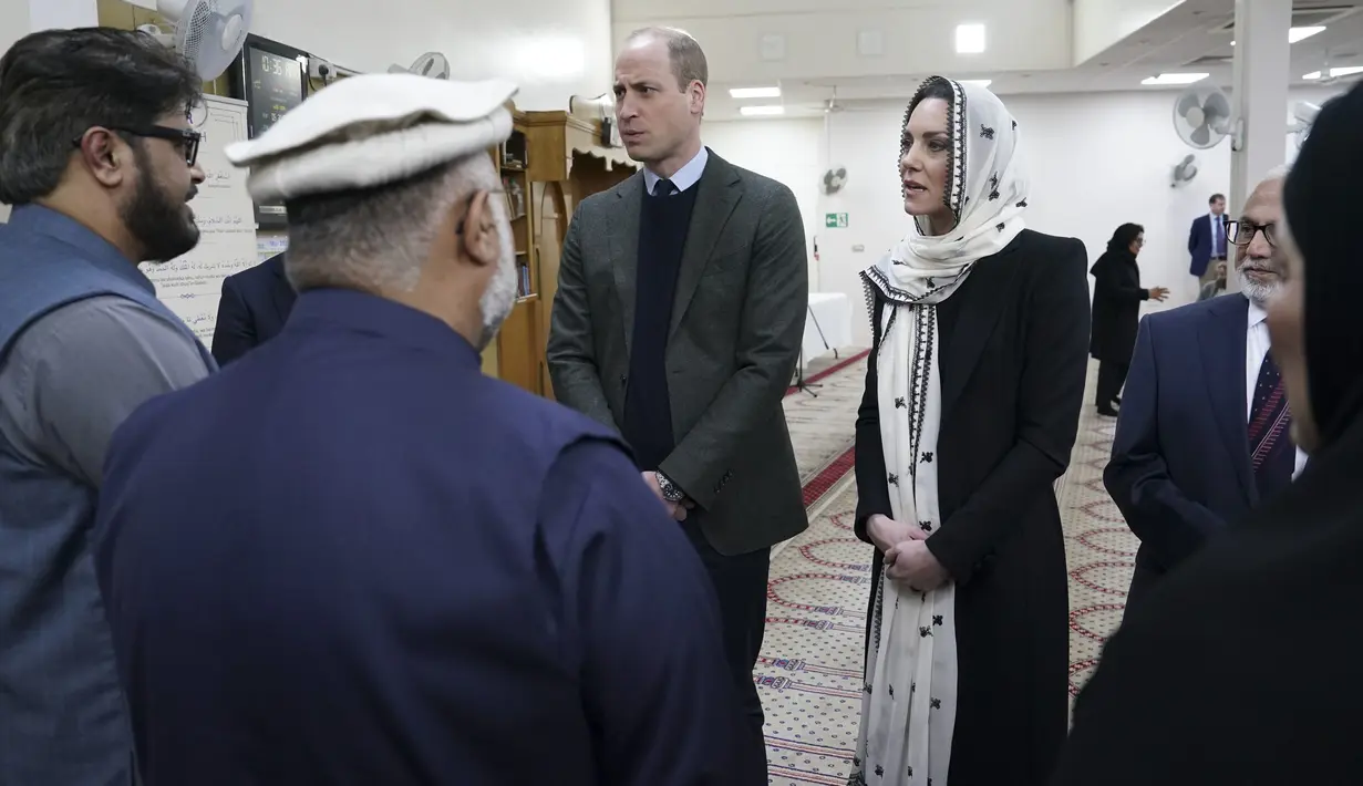Pangeran William dan sang istri, Kate Middleton, mengunjungi Hayes Muslim Centre yang berada di London, Inggris, Kamis (9/3/2023). Dari foto-foto yang beredar, keduanya juga tampak melepas sepatu dan hanya mengenakan kaus kaki saat masuk ke lokasi. (Arthur Edwards/Pool Photo via AP)