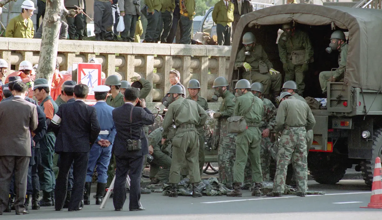 Tentara berkumpul di stasiun kereta bawah tanah Tsukiji setelah serangan gas sarin oleh sekte kiamat Aum Shinrikyo di Tokyo, Jepang, 20 Maret 1995. Serangan gas sarin membuat korban tersedak dan muntah, sebagian buta dan lumpuh. (JIJI PRESS/AFP)