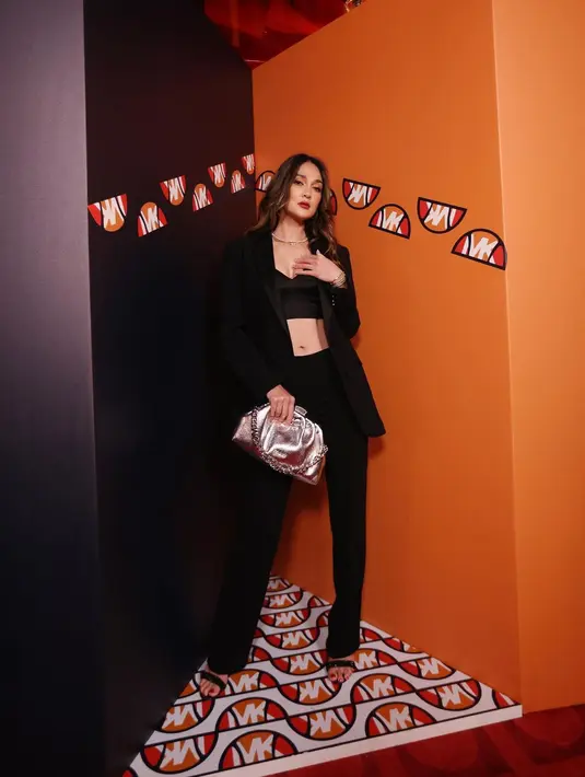 Dalam acara cocktail party Michael Kors di London, Luna Maya tampil edgy glamor dengan outfit serba hitam. Mengenakan crop top satin yang dipadukan dengan blazer dan celana hitam. (Instagram/lunamaya).