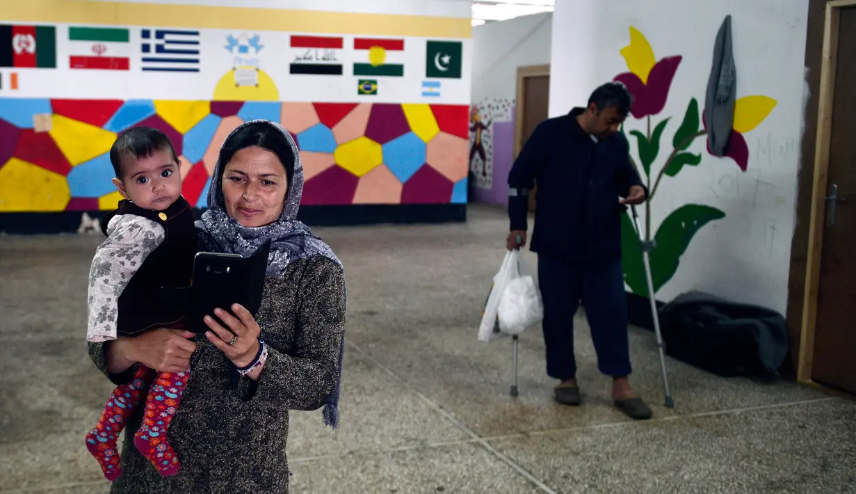 Sejumlah pengungsi saat beraktivitas di Kamp Oinofyta, Athena, Yunani (13/3). Kamp ini merupakan rumah bagi para pengungsi atau imigran, terutama dari Afghanistan. (AFP Photo / Louisa Gouliamaki)
