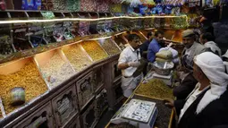 Warga membeli kacang-kacangan dan makanan manis di sebuah pasar menjelang Hari Raya Idul Fitri di Sanaa, Yaman, Jumat (22/5/2020). Idul Fitri menandai berakhirnya bulan suci Ramadan. (Xinhua/Mohammed Mohammed)