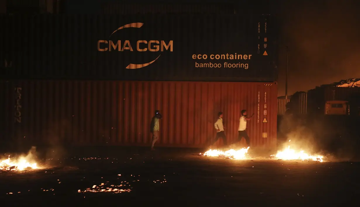Pria tak dikenal berlari setelah kebakaran terjadi di BM Inland Container Depot, perusahaan patungan Belanda-Bangladesh, di Chittagong, 216 kilometer (134 mil) tenggara ibu kota, Dhaka, Bangladesh, Minggu pagi (5/6/2022). Berdasarkan keterangan penduduk setempat, kebakaran itu disertai ledakan cukup kuat hingga memecahkan kaca jendela gedung-gedung yang terletak sekitar 4 kilometer dari lokasi kejadian. (AP Photo)