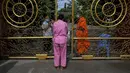 Warga antre untuk memberikan makanan dan sedekah kepada biksu Buddha saat Festival Pchum Ben (Festival Kematian) di luar pagoda di Phnom Penh, Kamboja, 24 September 2021. Pihak berwenang menghentikan perayaan Festival Kematian karena pandemi COVID-19. (TANG CHHIN Sothy/AFP)