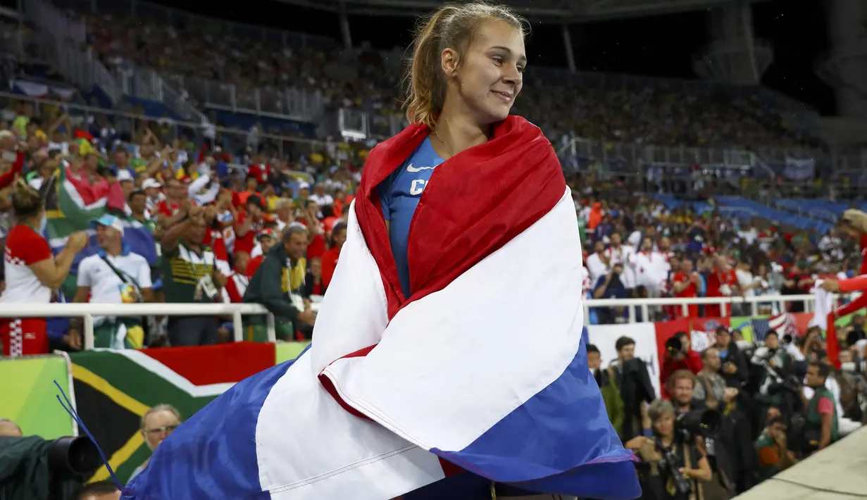 Sara Kolak berselimut bendera Kroasia usai meraih medali emas pada nomor lempar lembing putri Olimpiiade Rio 2016 di Stadion Olimpic, Rio de Janeiro (19/8/2016). (Reuters/Kai Pfaffenbach)