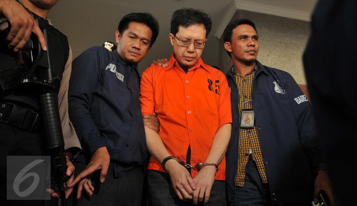 Buronan ‎kasus korupsi dana nasabah Bank Century, Hartawan Aluwi dikawal petugas keluar Bareskrim Mabes Polri, Jakarta, Jumat (22/4). Dengan pengawalan ketat anggota bersenjata laras panjang, Hartawan digelandang ke Kejagung. (Liputan6.com/Gempur M Surya)