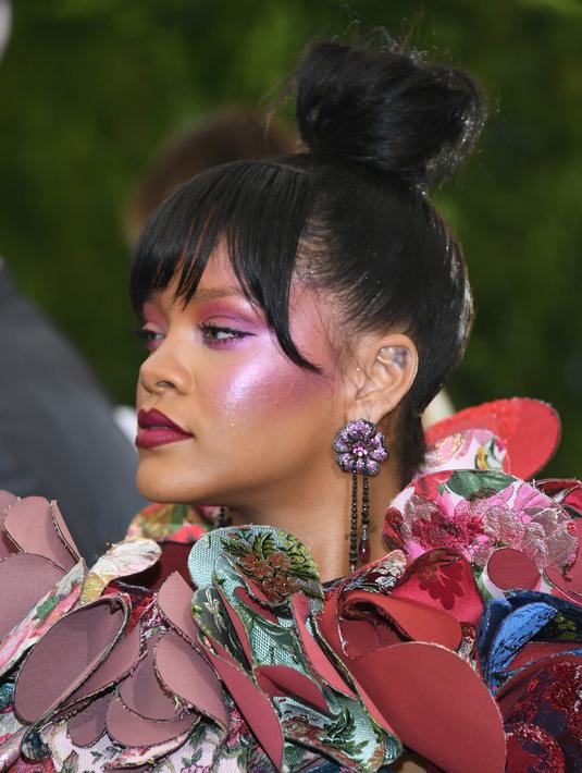 Penyanyi Rihanna berpose setibanya pada acara penggalangan dana Met Gala 2017 di New York, Senin (1/5). Untuk menyempurnakan penampilannya, Rihanna memilih gaya rambut cepol, dengan dandanan wajah yang didominasi warna merah muda. (Dia Dipasupil/AFP)