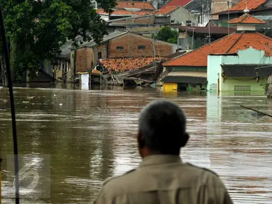 Warga menyaksikan luapan air kali Ciliwung yang menggenangi pemukiman di kawasan Rawajati, Jakarta, Selasa (8/3/2016). Akibat banjir kiriman dari Bogor, ratusan rumah di kawasan Rawajati terendam hingga kedalaman 120cm. (Liputan6.com/Helmi Fithriansyah)