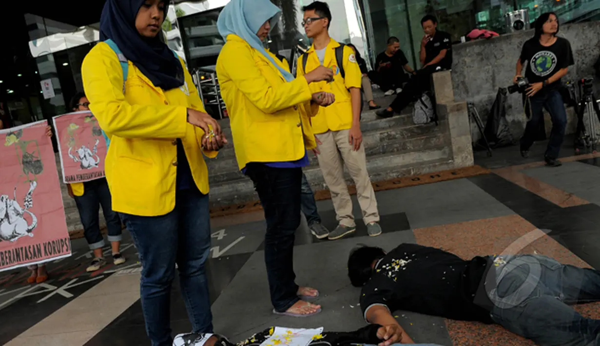 Dua orang mahasiswi menaburkan bunga saat aksi teaterikal di di depan gedung KPK, Jakarta, Kamis (5/3/2015). Aksi tersebut menuntut pemerintah untuk segera menghentikan kriminalisasi KPK (Liputan6.com/Faisal R Syam)