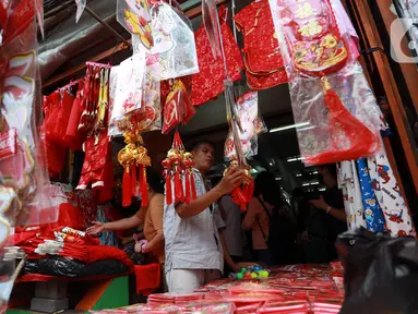 Warga melihat-lihat pernak-pernik Imlek di Kawasan Pasar Glodok Pancoran, Jakarta Barat, Jumat (13/1/2023). Menjelang Imlek yang akan jatuh pada tanggal 22 Januari 2023 mendatang, para pedagang musiman yang menjual pernak-pernik mulai ramai. (Liputan6.com/Johan Tallo)