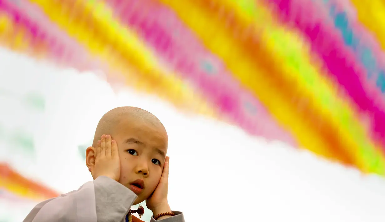 Seorang anak kecil berpakaian biksu saat upacara pemberkatan Biksu di   kuil Jogye, Seoul, Senin   (11/5/2015). Sepuluh anak diberikan kesempatan mencicipi kehidupan biksu di kuil selama dua minggu. (REUTERS/Thomas Peter)
