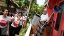 Relawan dari Gerakan Aksi Srikandi Coblos Ahok (Gadis Ahok) memberikan sapu dan tempat sampah ke warga di kawasan Cipete, Jakarta Selatan, Senin (26/12). Sebanyak 150an kantong sampah dan sapu dibagikan ke warga. (Liputan6.com/Gempur M Surya)