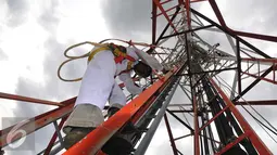 Teknisi turun dari menara jaringan telekomunikasi usai melakukan perawatan, Jakarta, Rabu (2/11). Pemerintah berharap masyarakat akan semakin dapat menikmati manfaat digital sesuai dengan target pemerintah. (Liputan6.com/Angga Yuniar)