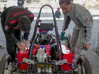 Mahasiswa mengecek kondisi Mobil listrik sebelum dipertandingan dalam ajang pameran IIMS 2019 di JIExpo Kemayoran, Jakarta, Kamis (25/4). Kompetisi yang di ikuti berbagai kampus di Indonesia tersebut untuk mengembangkan kemampuan anak bangsa di bidang teknologi otomotif. (Liputan6.com/Faizal Fanani)