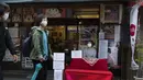 Seorang peramal yang menyebut dirinya Buchiko menunggu pelanggan saat orang-orang berjalan melalui jalan perbelanjaan di Tokyo (15/10/2020). Ibukota Jepang mengonfirmasi lebih dari 280 kasus virus korona baru pada hari Kamis. (AP Photo/Hiro Komae)