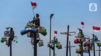 Peserta mengikuti perlombaan panjat pinang di pantai Ancol, Jakarta, Sabtu (17/8/2024). (Liputan6.com/Angga Yuniar)