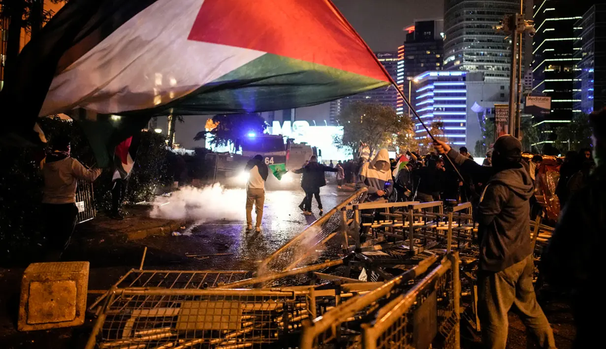 Rekaman video yang beredar di media sosial memperlihatkan sejumlah demonstran melemparkan petasan ke gedung Konsulat Israel di Istanbul, memanjat pagarnya, dan berusaha membuat gedung itu terbakar. (AP Photo/Emrah Gurel)