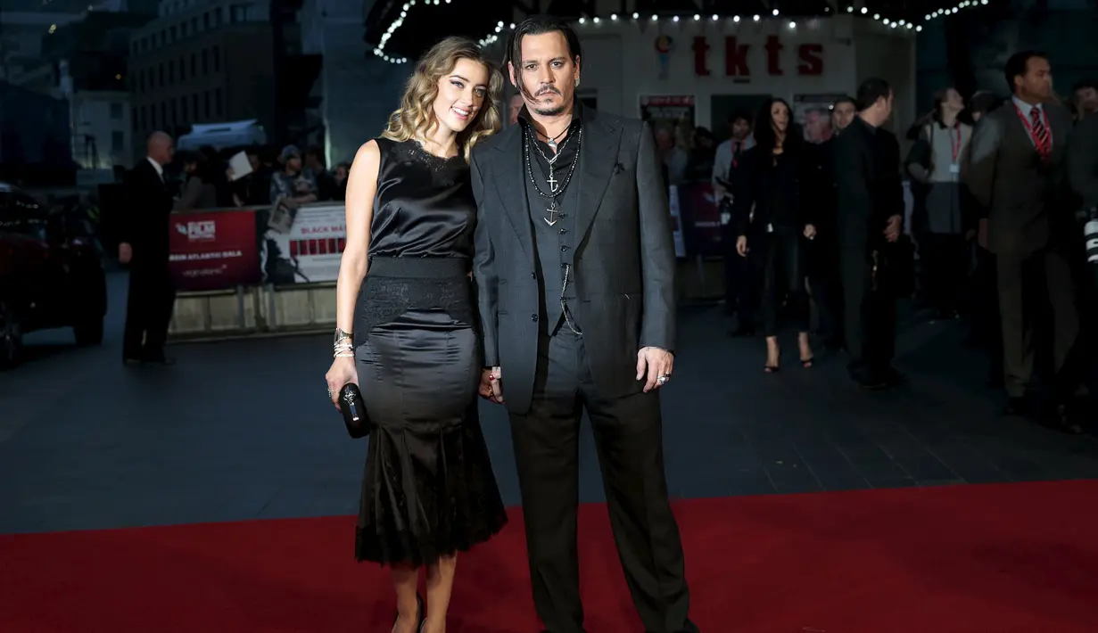 Johnny Depp (kanan) dan istri Amber Heard berpose depan kamera saat menghadiri pemutaran perdana film "Black Mass " di London, Inggris, Minggu (11/10/2015). Johnny berperan sebagai James " Whitey " Bulger dalam film Black Mass. (REUTERS/Suzanne Plunkett)