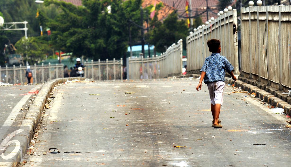Seorang anak melintas di Jalan Jatinegara Barat Jakarta, Kamis (20/8/2015). Jalan Jatinegara Barat ditutup saat penggusuran warga yang tinggal di bantaran Kali Ciliwung di Kampung Pulo, Jakarta Timur. (Liputan6.com/HelmiFithriansyah)