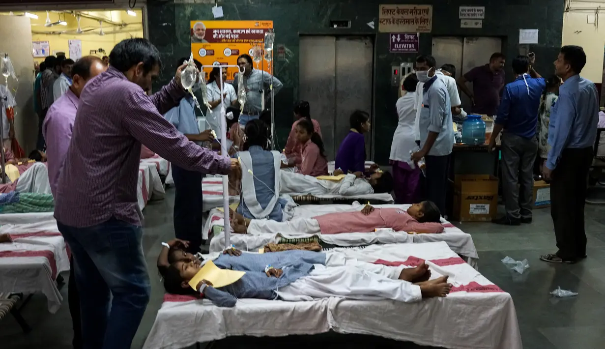 Sebagian siswi mendapat perawatan di lorong rumah sakit menyusul kebocoran gas dari sebuah depot kontainer di New Delhi, India, Sabtu (6/5). Lebih dari 100 murid dievakuasi dari sekolah Rani Jhansi di New Delhi dalam insiden tersebut. (Chandan KHANNA/AFP)
