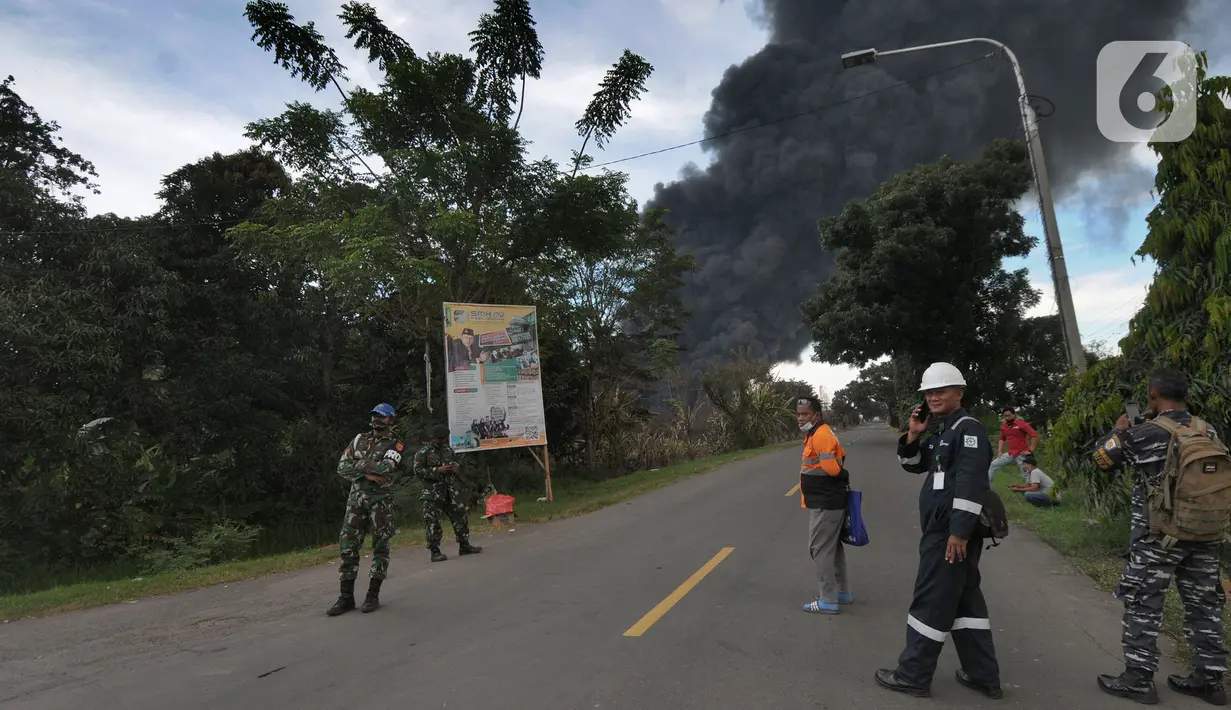 Anggota TNI berjaga di lokasi terbakarnya kilang minyak di Jalan Raya Balongan-Indramayu, Kabupaten Indramayu, Jawa Barat, Senin (29/3/2021).  Dampak dari terbakarnya kilang minyak Balongan milik PT Pertamina itu mengakibatkan Jalan Raya Balongan-Indramayu ditutup total. (merdeka.com/Arie Basuki)