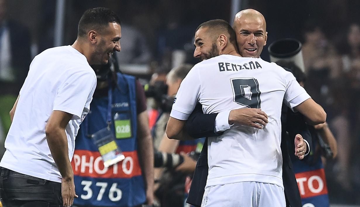 Karim Benzema memeluk Zidane saat meraih trofi Liga Champions di San Siro Stadium, Milan, (28/5/2016). Zinedine mundur sebagai pelatih Madrid 31 Mei 2018. (AFP/Filippo Monteforte)