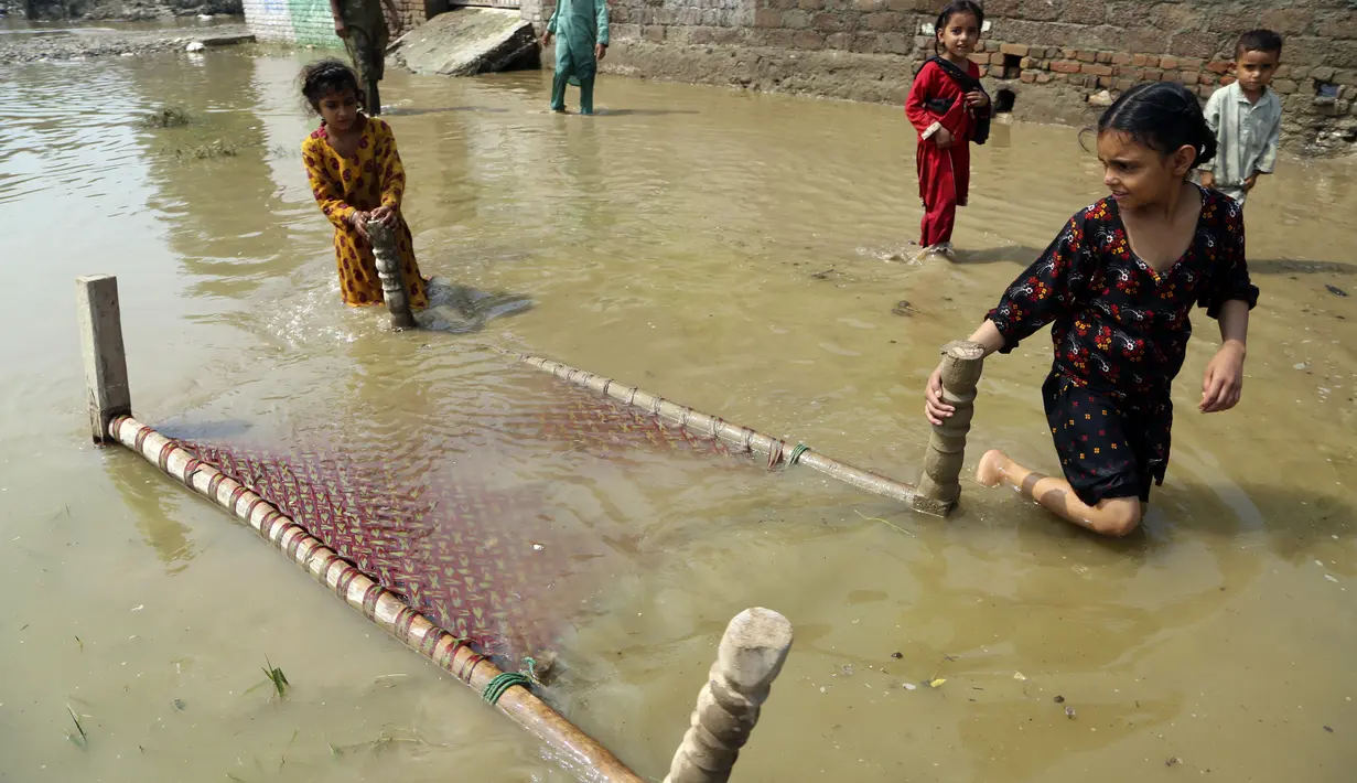 Anak-anak menyelamatkan sebuah ranjang bayi dari rumah mereka yang terkena banjir, di Charsadda, Pakistan, Rabu (31/8/2022). Para pejabat di Pakistan menyampaikan kekhawatiran Rabu atas penyebaran penyakit yang ditularkan melalui air di antara ribuan korban banjir saat air banjir dari hujan monsun yang kuat mulai surut di banyak bagian negara. (AP Photo/Mohammad Sajjad)