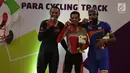 Pebalap sepeda Indonesia, M. Fadli Imammuddin  bersama pebalap Malaysia Mohd Najib dan Singh Harinder dari India mengigit medali usai bertanding  pada nomor 4000 meter individual pursuit C4, Jakarta Timur, Jumat (12/10). (Merdeka.com/Imam Buhori)