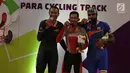 Pebalap sepeda Indonesia, M. Fadli Imammuddin  bersama pebalap Malaysia Mohd Najib dan Singh Harinder dari India mengigit medali usai bertanding  pada nomor 4000 meter individual pursuit C4, Jakarta Timur, Jumat (12/10). (Merdeka.com/Imam Buhori)