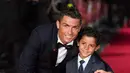 Penyerang Real Madrid, Cristiano Ronaldo bersama anaknya Cristiano Ronaldo Jr. berpose saat pemutaran film perdana 'Ronaldo' di Leicester Square, London, Inggris (9/11). (Reuters/Stefan Wermuth)