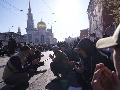 Sekelompok pria Sholat saat umat Islam lainnya meninggalkan kawasan itu selama perayaan liburan Idul Fitri di Masjid Katedral Moskow, masjid utama Moskow, terbesar di Rusia dan Eropa di Moskow, Rusia, Jumat dini hari, 21 April 2023. (AP Photo/Alexander Zemlianichenko)