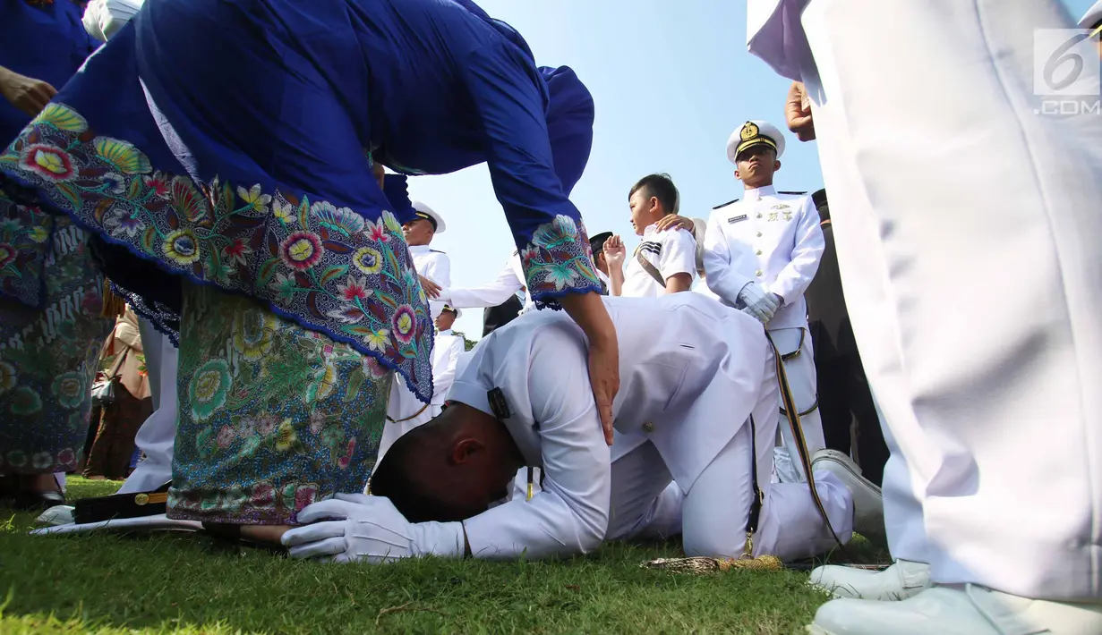 Seorang Perwira Remaja sujud di kaki ibunya usai dilantik Presiden Joko Widodo di Istana Merdeka, Jakarta, Selasa (25/7). Dalam acara ini Jokowi melantik 729 orang Calon Perwira Remaja (Capaja) TNI-Polri. (Liputan6.com/Angga Yuniar)