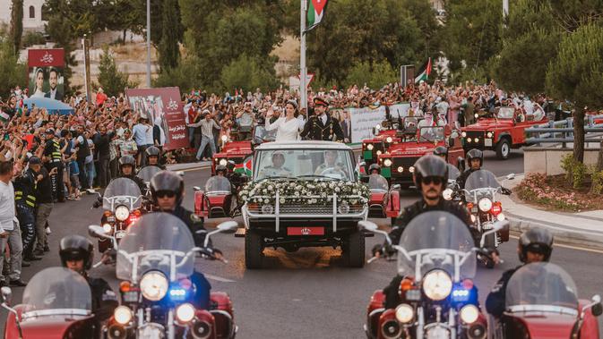 Yang Mulia Putra Mahkota Al Hussein dan Putri Rajwa Al Hussein dalam iring-iringan dalam mobil merah. (Sumber: Twitter/@RHCJO)