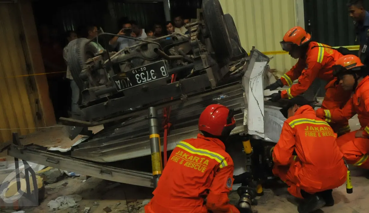Petugas Damkar melakukan evakuasi pada mobil boks yang jatuh dari lantai 3 Pasar Cipulir, Jakarta, Selasa, (19/1/2016). Dua orang dikabarkan tewas dalam peristiwa tersebut. (Liputan6.com/Faisal R Syam)
