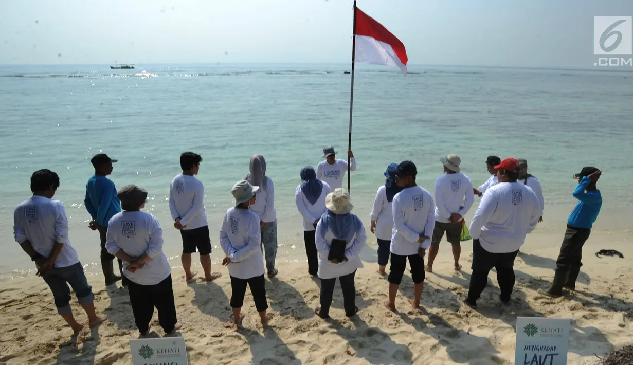 Aktivis Yayasan Kehati Jakarta  bersiap melakukan upacara bendera menghadap laut dalam rangka HUT ke-74 RI di Pulau Sangiang, Banten, Minggu (18/8/2019). Dalam kegiatan ini juga dilakukan akbir bersih pantai dengan memungut sampah-sampah di seputaran pantai. (merdeka.com/Arie Basuki)