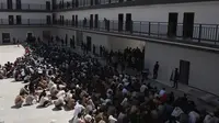 Warga&nbsp;China, Vietnam, dan Ethiopia, yang diyakini telah diperdagangkan dan dipaksa bekerja di pusat-pusat penipuan, duduk dengan wajah tertutup saat ditahan setelah dibebaskan dari Distrik Myawaddy, Myanmar, Rabu (26/2/2025). (Dok. AP/Thanaphon Wuttison)