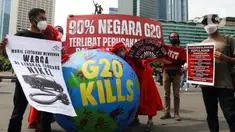 Aktivis iklim melakukan teatrikal dengan membawa bola dunia saat aksi di kawasan Bundaran Hotel Indonesia, Jakarta, Minggu (13/11/2022). Aksi yang digelar berbarengan dengan penyelenggaraan G20 ini meminta pemimpin dunia menemukan solusi bersama atas kondisi ekonomi global. (Liputan6.com/Herman Zakharia)