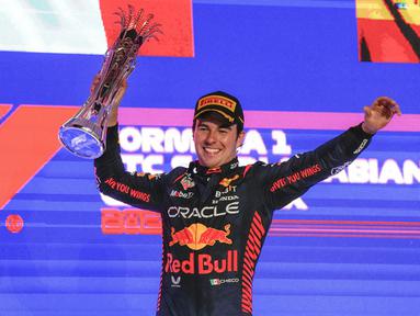 Pebalap Red Bull, Sergio Perez merayakan kemenangan setelah finis pertama saat Formula 1 GP Arab Saudi 2023 yang berlangsung di Jeddah Corniche Circuit, Senin (20/03/2023) WIB. Kemenangan tersebut menjadi yang kelima di ajang balap Formula 1 bagi pebalap asal Meksiko tersebut. (AP Photo/Hassan Ammar)