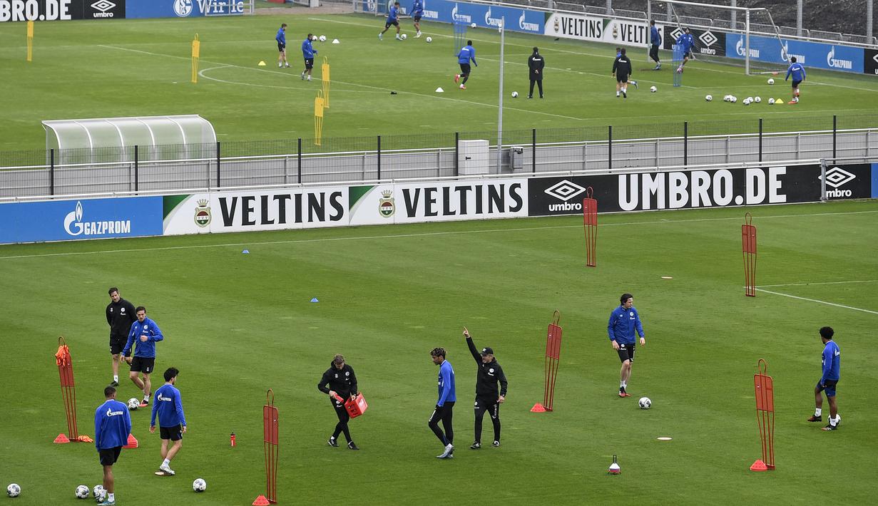 Sejumlah pemain Schalke tetap menjaga jarak saat mengikuti sesi latihan di Gelsenkirchen, Jerman, Rabu, (29/4/2020). Schalke kembali menggelar latihan jelang rencana akan kembali bergulirnya Bundesliga di tengah pandemi COVID-19 pada Mei mendatang. (AP/Martin Meissner)