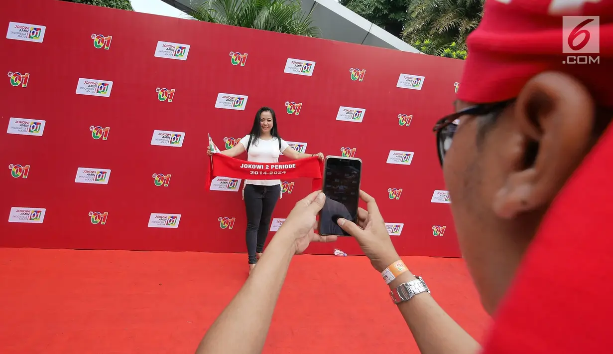 Pendukung capres nomor urut 01 Joko Widodo berpose saat tiba di Sentul International Convention Center, Bogor, Minggu (24/2). Konvensi Rakyat ini dihadiri TKN, partai politik Koalisi Indonesia Kerja (KIK), dan relawan. (Liputan6.com/Herman Zakharia)