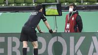 Wasit Manuel Grafe memeriksa rekaman VAR dalam laga semifinal DFB Pokal antara Werder Bremen melawan RB Leipzig di Weserstadion, Bremen, Jumat (30/4/2021). Werder Bremen kalah 1-2 dari RB Leipzig melalui babak perpanjangan waktu. (AP/Carmen Jaspersen/Pool)
