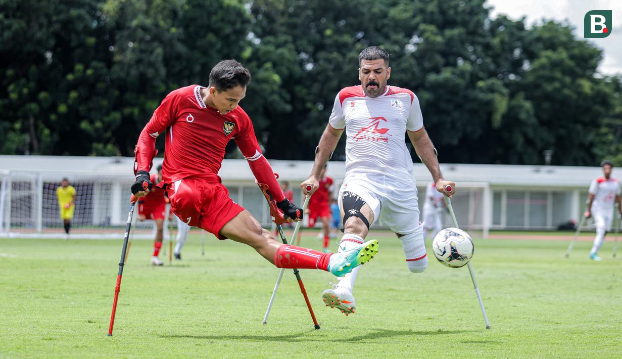 <p>Pemain Timnas Amputasi Indonesia, Agung Rizki Satria (kiri) berusaha mengumpan bola dibayangi pemain Iran dalam laga Grup A Kualifikasi Piala Dunia Amputasi 2026 di Stadion Madya, Senayan, Jakarta, Kamis (13/11/2025). (Bola.com/Bagaskara Lazuardi)</p>