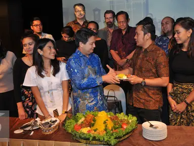 Sutradara Hanung Bramantyo menerima potongan tumpeng saat Syukuran Film Kartini di XXI Jakarta Theater, Jakarta, Kamis (14/7). Rencananya film Kartini akan tayang di bioskop pada April 2017. (Liputan6.com/Gempur M Surya)