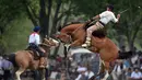 Seorang gaucho atau koboi menaiki kuda liar saat kompetisi rodeo di San Antonio de Areco , Argentina, Minggu (8/11). Dalam acara ini, para gaucho atau koboi saling bersaing menunjukkan keahlian mereka menunggangi kuda liar. (AFP PHOTO / Eitan Abramovich)