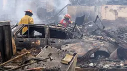 Petugas pemadam memeriksa lokasi kebakaran besar yang melanda permukiman Cantagallo di Lima, Peru, Jumat (4/11). Kebakaran mengakibatkan sekitar 300 rumah rata dengan tanah dan memaksa ribuan warganya mengungsi. (REUTERS/Guadalupe Pardo)