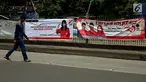 Pejalan kaki berjalan di depan spanduk partai politik yang terpampang di Jalan Sultan Agung, Manggarai, Jakarta, Selasa (16/1). Memasuki 2018, parpol berlomba mengambil hati rakyat dengan berbagai janji terpampang di spanduknya. (Liputan6.com/JohanTallo)
